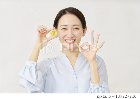 白背景でビットコインを持つ女性 137227210