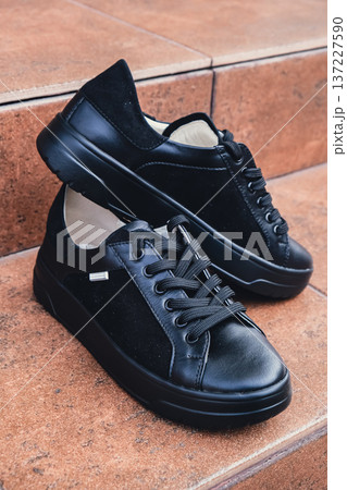 Elegant black leather womens shoes blank product for branding displayed. New casual female sneakers no-brand footwear e-commerce. No logo product 137227590