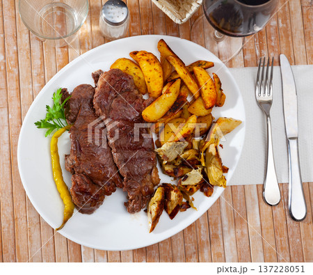 Beef steak with potatoes and artichokes Beef steak with potatoes and artichokes 137228051