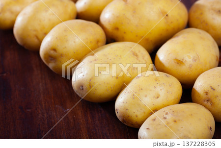 Raw fresh young potatoes at wooden table in home kitchen 137228305