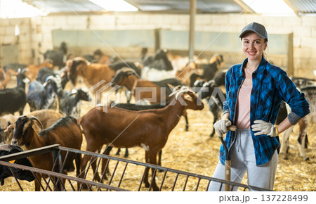 Confident positive female farmer posing in goat shed Confident positive female farmer posing in goat shed 137228499