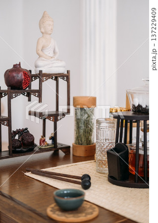 Buddha statue meditation. Chinese tea ceremony. Healthy herbal drink transparent brew water tasty pomegranate liquid clear cup glass teapot for calming fresh beverage. 137229409