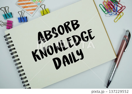 Absorb Knowledge Daily text message written on notepad with stationery flat lay on white background Absorb Knowledge Daily text message written on notepad with stationery flat lay on white background 137229552