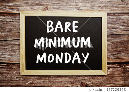 Bare Minimum Monday text on Blackboard and alarm clock on wooden background 137229568