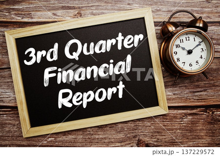 3rd Quarter Financial Report text on Blackboard and alarm clock on wooden background 137229572