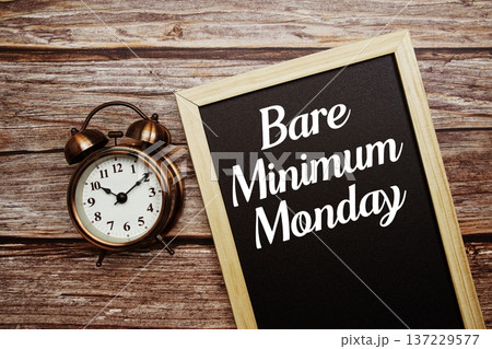 Bare Minimum Monday text on Blackboard and alarm clock on wooden background Bare Minimum Monday text on Blackboard and alarm clock on wooden background 137229577