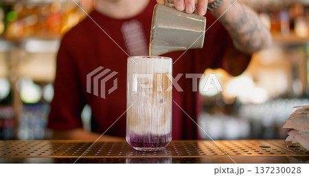 Cocktail recipe. Making beverage mix. Bartender pouring cream from clay pitcher to glass. Refreshing drink with flavored whipped top. Cocktail recipe. Making beverage mix. Bartender pouring cream from clay pitcher to glass. Refreshing drink with flavored whipped top. 137230028