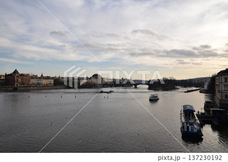夕暮れ時のヴルタヴァ川とプラハの美しい街並み 137230192