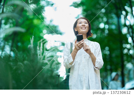 屋外でスマートフォンを使う女性 137230612