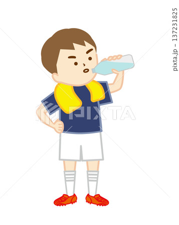 首にタオルを巻いて腰に手を当て、立って水分補給をするサッカー少年 137231825