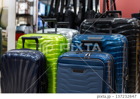 Suitcases of various sizes at travel store. Finding suitcase by size and style is challenging. Wide selection of wheeled bags with retractable handles. Unique design and color for airplane bag Suitcases of various sizes at travel store. Finding suitcase by size and style is challenging. Wide selection of wheeled bags with retractable handles. Unique design and color for airplane bag 137232647