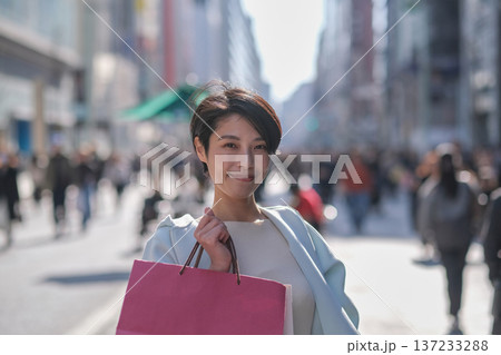 ショッピングバッグを持って微笑む女性 137233288