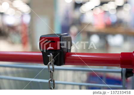 Coin operated lock on handle of shopping cart. Insert coin to release your cart. Return cart to supermarket to retrieve your coin. Locker provides cart control and security at grocery store 137233458