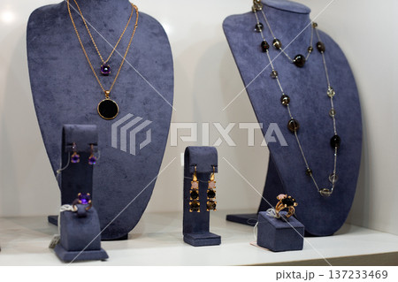 Set of custom jewelry for wealthy client. Precious pieces for special customer. Symbol of specialness and uniqueness in jewelry. Great love for unique accessories with jewelry on stand Set of custom jewelry for wealthy client. Precious pieces for special customer. Symbol of specialness and uniqueness in jewelry. Great love for unique accessories with jewelry on stand 137233469