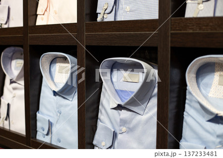Light blue shirt as alternative to traditional white shirt. Shelf full of light blue shirts in various styles. Solid colors, checkered patterns and striped shirts. Buying new shirt for your look Light blue shirt as alternative to traditional white shirt. Shelf full of light blue shirts in various styles. Solid colors, checkered patterns and striped shirts. Buying new shirt for your look 137233481