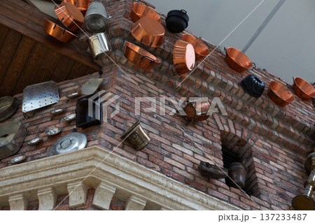 Kitchen utensils in brick wall of old building after being hit by catapult. Medieval war and aftermath of building being destroyed by throwing everything at it. Damaged building, abstract concept 137233487