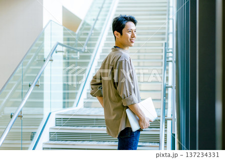 オフィスの廊下にいるミドル男性 オフィスの廊下にいるミドル男性 137234331