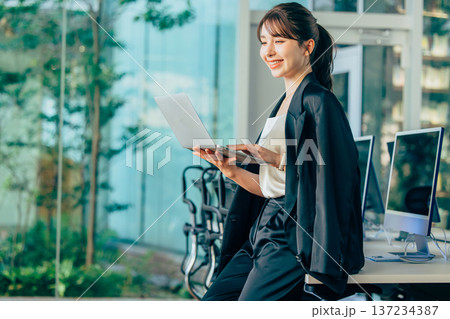 オフィスでパソコンを使って仕事する外国人女性 オフィスでパソコンを使って仕事する外国人女性 137234387