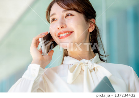 スマホで通話する女性 ビジネス スマホで通話する女性 ビジネス 137234432
