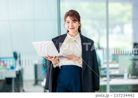 オフィスでノートパソコンを操作する若いビジネスウーマン 137234442
