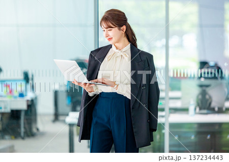 オフィスでノートパソコンを操作する若いビジネスウーマン 137234443