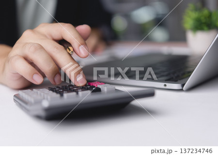 Accountant hand using calculator holding pen computing financial tax office desk laptop. Business male analyzing budget investment cost. Corporate finance economy accounting money concept. 137234746