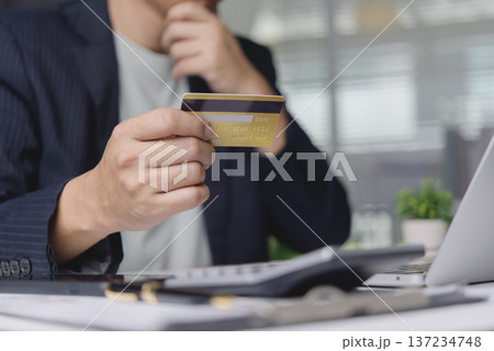 Close up man looking credit card calculating debt expense calculator. Serious person planning budget finance investment problem. Economic crisis money bankruptcy idea. Close up man looking credit card calculating debt expense calculator. Serious person planning budget finance investment problem. Economic crisis money bankruptcy idea. 137234748
