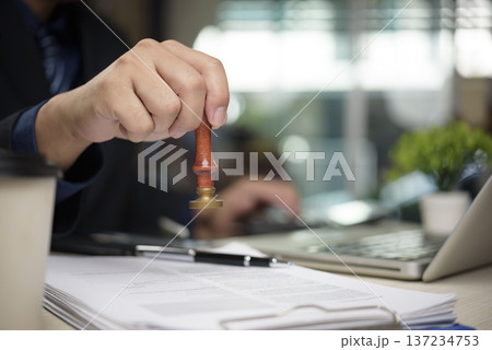 Close up lawyer using vintage wood stamp official certificate form office. Professional worker checking paperwork signature investment deal. Business law strategy success confirmed. 137234753