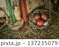 Ostara spring equinox celebration set with red eggs in nest, green candles and ancient book with brass key on hay background. 137235079