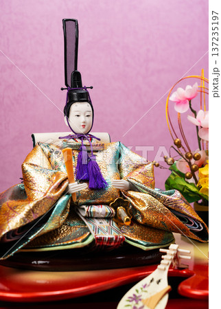 琵琶のミニチュアと美しい金襴衣装をまとったお内裏様・男雛のクローズアップ（ひな祭り・桃の節句） 137235197