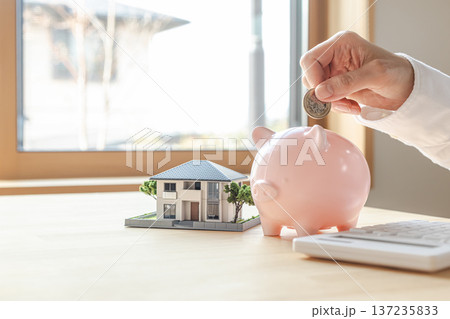 家の模型と貯金箱　住宅購入や住宅ローンのイメージ素材 137235833