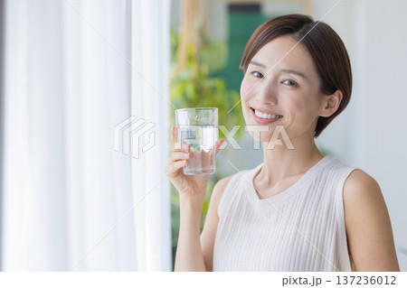 ビューティーイメージ　窓辺で水を飲む女性 137236012