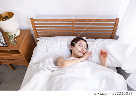 ベッドで熟睡している女性　俯瞰 137236017