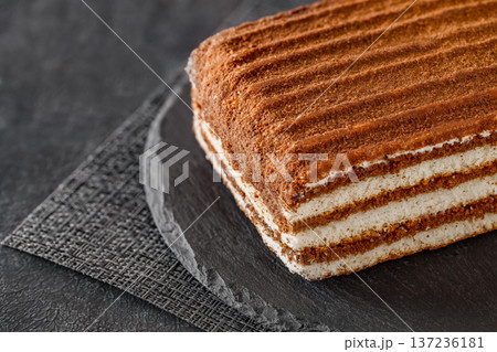 Layered chocolate cake on slate stone plate round, dark background, selective focus Layered chocolate cake on slate stone plate round, dark background, selective focus 137236181