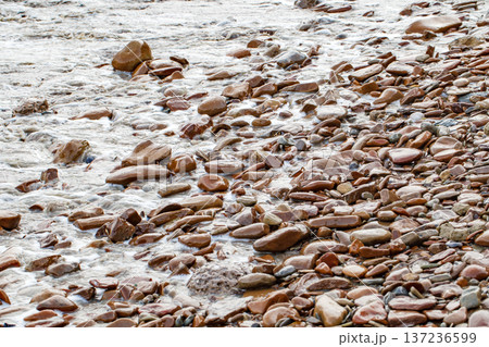 Sea surf and wet pebbles on the coast close-up Sea surf and wet pebbles on the coast close-up 137236599