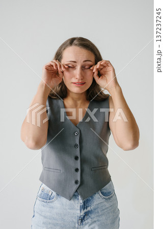 Title: Crying Woman Rubbing Eyes in Studio 137237245