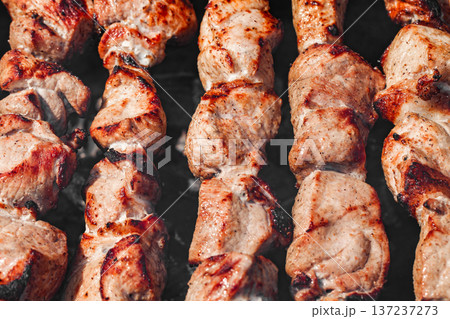 Fried meat in chunks, shish kebab on skewers, close-up, selective focus Fried meat in chunks, shish kebab on skewers, close-up, selective focus 137237273