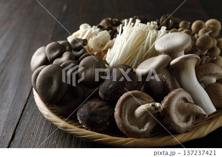 笊に盛った色々な種類のキノコ　木目背景 137237421