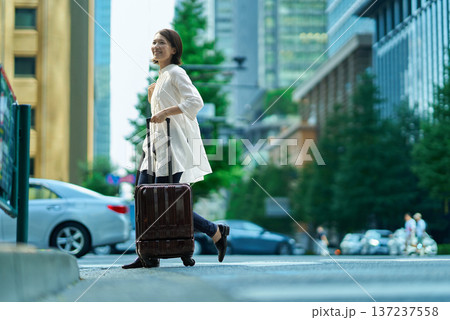 スーツケースを持って街を歩く女性 137237558