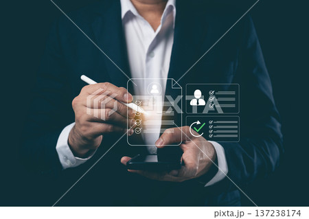 Businessman using stylus with smartphone to manage digital human resources profile and checklist on virtual screen, recruitment and employee evaluation concept 137238174