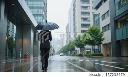 雨の日に傘をさして歩くスーツの女性 137238679