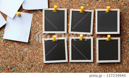 set of four blank photo frames, each with a white background and black border, is neatly displayed in the top left corner of an old-fashioned brown wooden corkboard covered in other white sticky notes 137239940