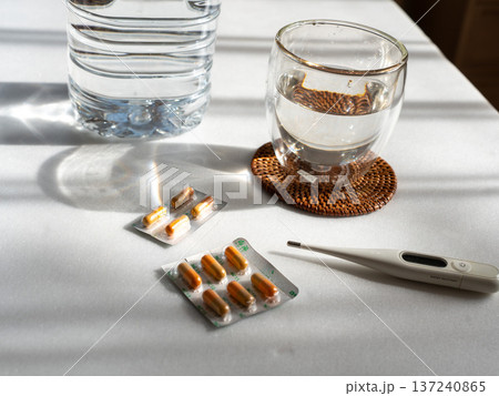 体温計と薬と水が入ったコップ 137240865