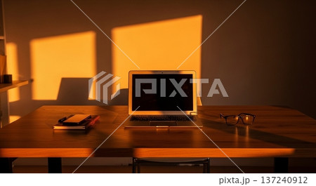 木製デスク上の携帯型計算機と業務資料表示画面の室内風景 137240912