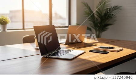 木製デスク上の携帯型計算機と業務資料表示画面の室内風景 137240940
