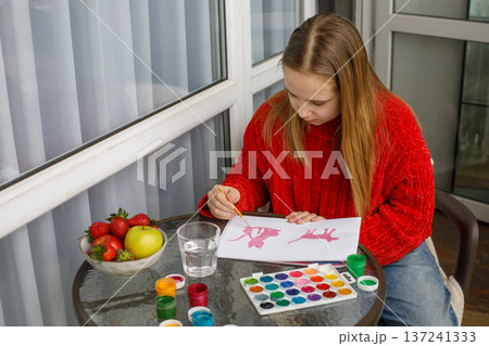 Enthusiastic child drawing pink cats in a sketchbook. Young preteen girl painting Enthusiastic child drawing pink cats in a sketchbook. Young preteen girl painting 137241333