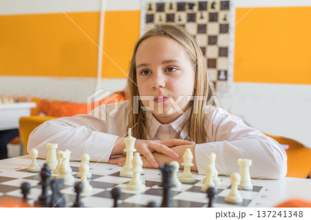 Thinking child school student on chess lesson indoor. Young girl Thinking child school student on chess lesson indoor. Young girl 137241348
