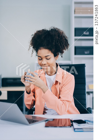 Smiling businesswoman working on laptop in office Smiling businesswoman working on laptop in office 137241863