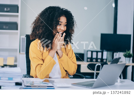 Pretty female freelancer working on laptop while sitting on modern coworking background Pretty female freelancer working on laptop while sitting on modern coworking background 137241892