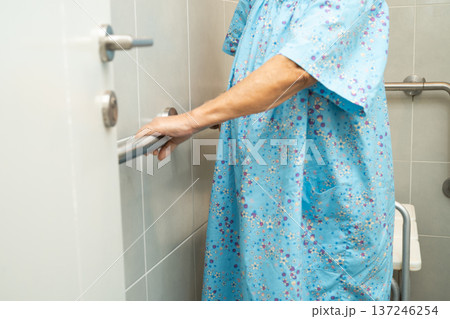 Asian elderly woman patient use toilet bathroom handle security in nursing hospital, healthy strong medical concept. 137246254